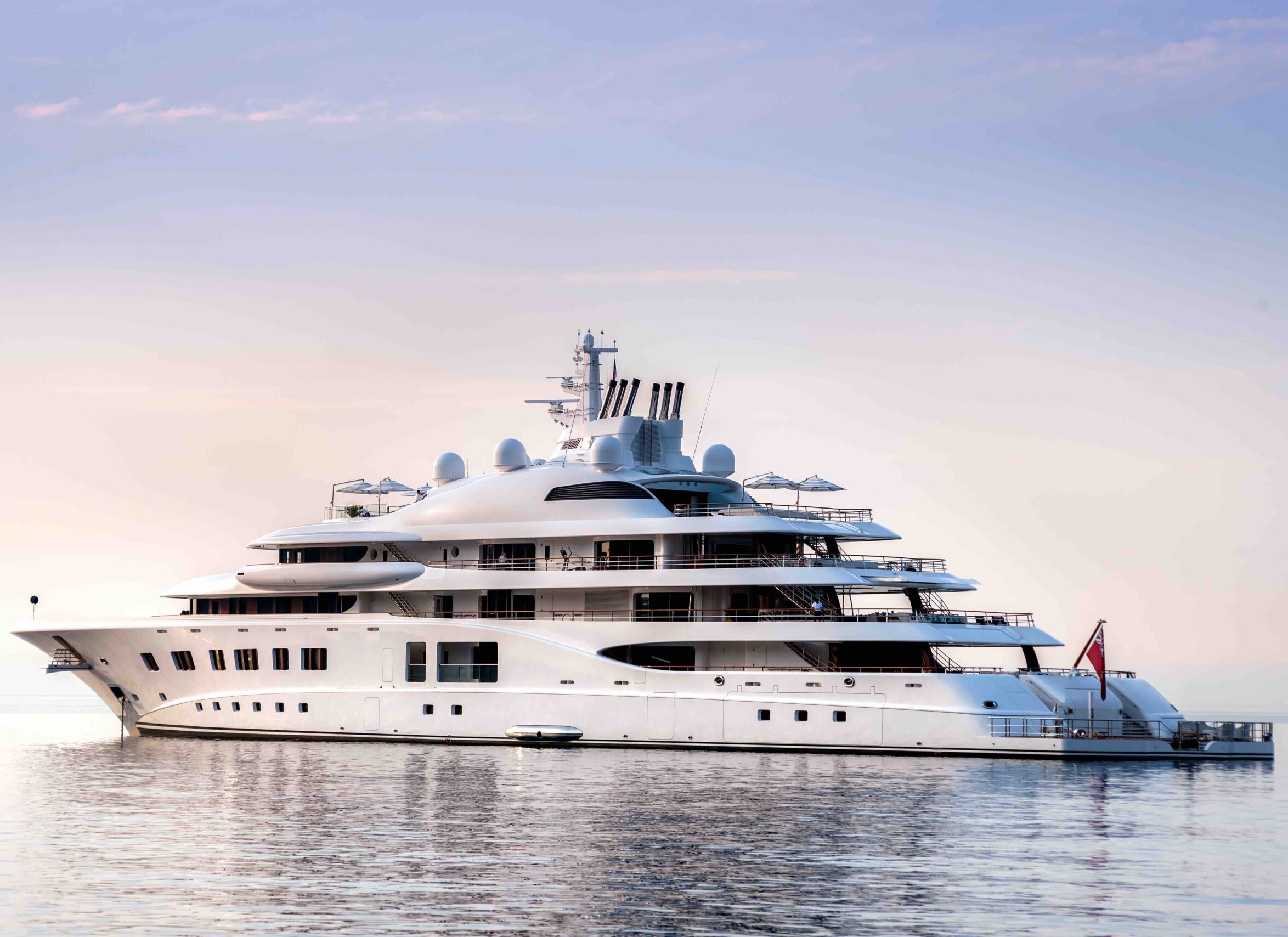 Mega yacht at anchor in a beautiful calm morning, with purple and blue tones